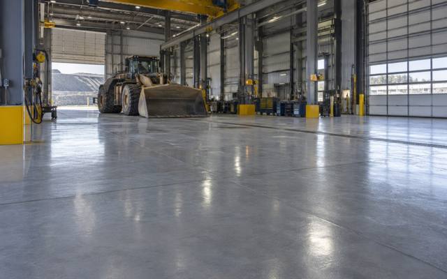 Grey epoxy floor in a heavy equipment shop with an overhead crane in Sherwood Park